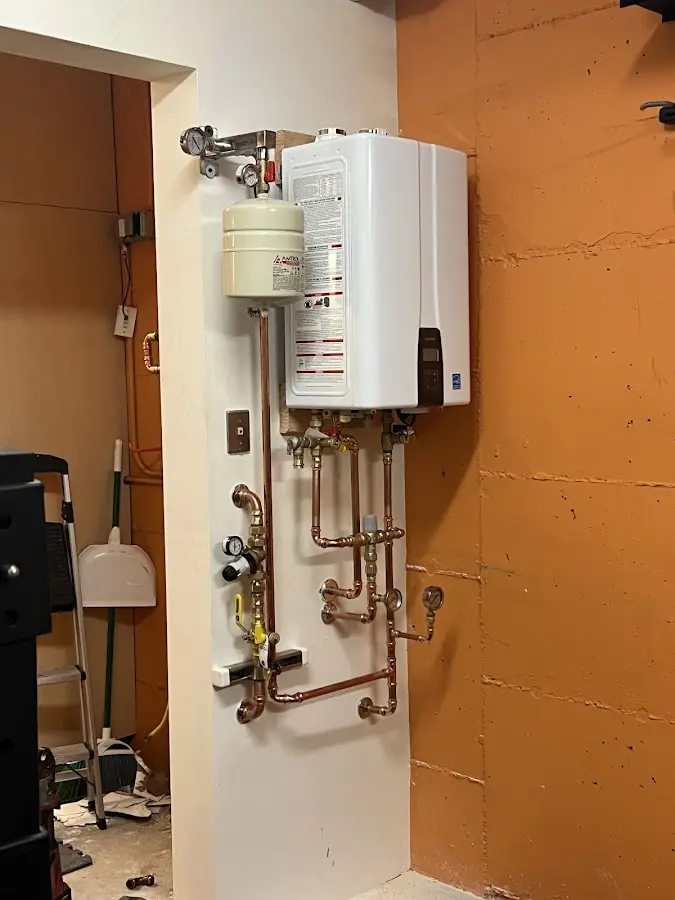 Plumbing technician inspecting water heater connections in East Porterville